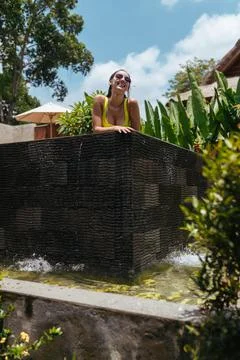 A view of the pool towering above the ground from which a girl in a swimsuit and Stock Photos