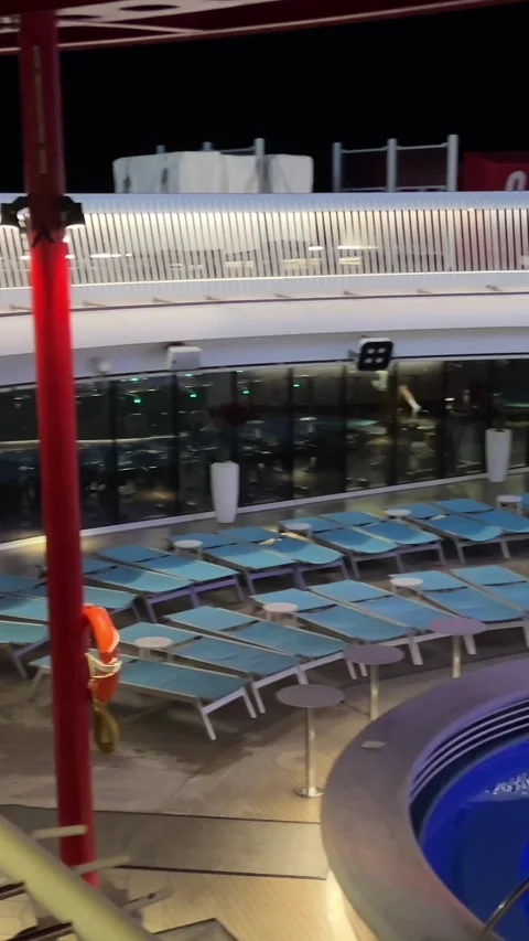 View of the pool on the upper deck of a cruise ship jacuzzi pool gym dark sky Stock Footage 295553626