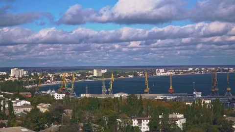 A view of a port with cranes on the bay. Nice clouds are flying across the sky. Stock Footage 102724789