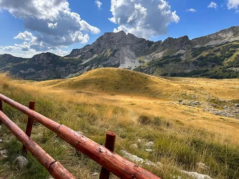 View as on the postcard: mountains and authentic fence of the village house Stock Photos