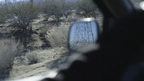 View of power towers from a side mirror of a driving car in slow motion Stock-Footage 92104106