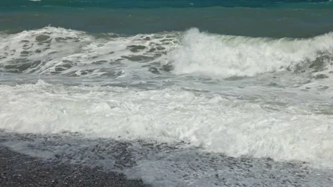 View of powerful Mediterranean Sea waves breaking into foam along pebble shore Stock Footage 346525601