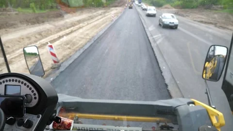 View on process of roadwork from inside cabin of steamroller. Roller laying new Stock Footage 326645780