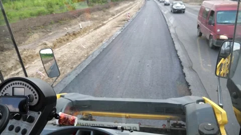 View on process of roadwork from inside cabin of steamroller. Roller laying new Vidéo 335817948