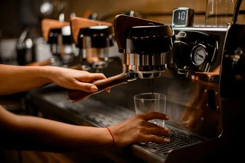View of professional coffee machine with which female barista prepares coffee Stock Photos