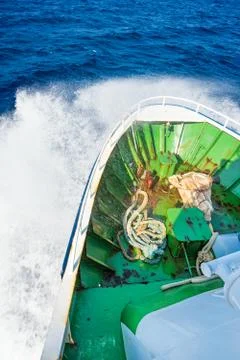 View of prow of ship hitting wave on open sea Stock Photos