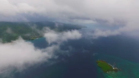 View from quadrocopters among the clouds over the ocean and the island with Stock Footage 72148349