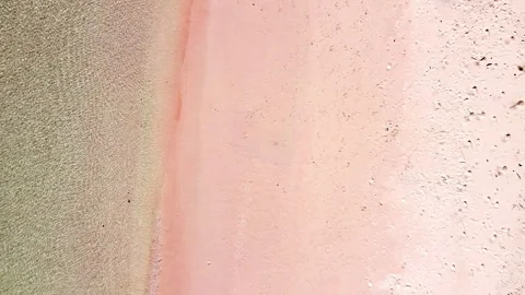 The view of a quiet pink beach with wave, drone top view zooming out Stock Footage 276159562