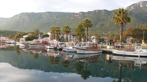 View Of A Quiet River With Many Moored Boats And Mountain Range In A Background Stock Footage 195981020