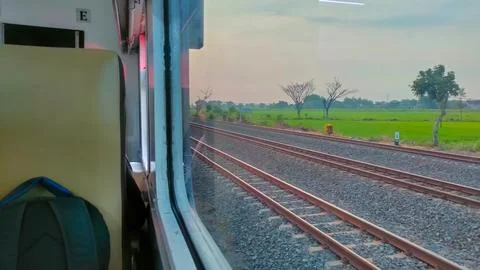 View of the rail line outside the train window, traveling by passenger train Stock Photos