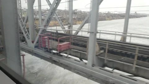 View of the railway bridge over the river in spring from the window of a moving  Video stock 174357660