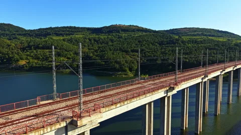 View of a railway bridge over a river with green hills in the background during Stock Footage 341614128