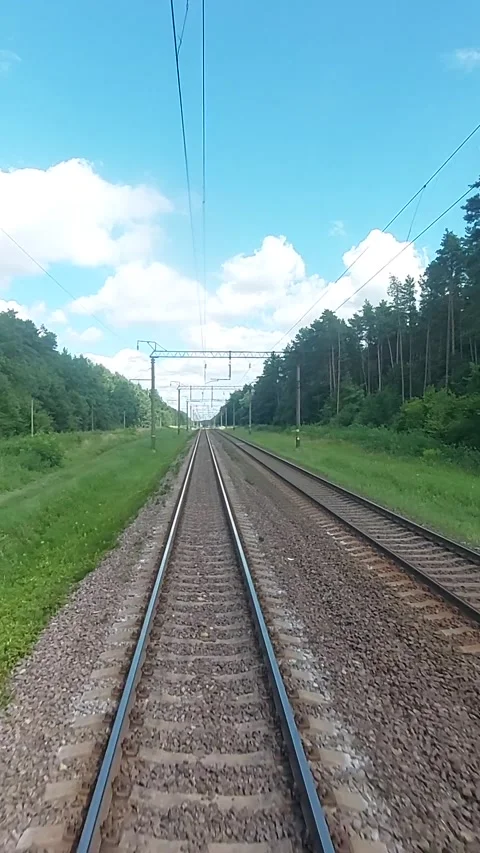 A view of the railway from the last car of a train. The train rushes along the Stock Footage 318529551