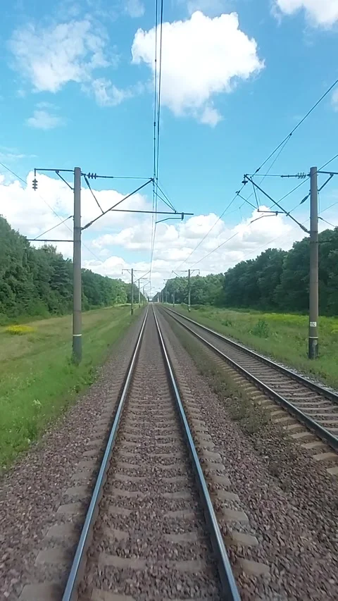 A view of the railway from the last car of a train. The train rushes along the Stock Footage 320430799