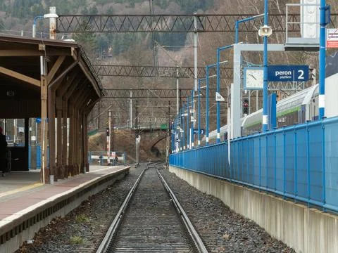 A view of railway tracks at a quiet train station with a wooden shelter and 스톡 사진