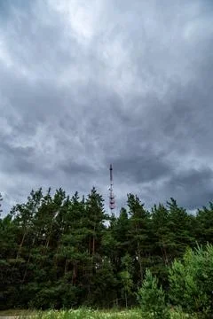View of rain clouds with forest and mobile tower antenna in the background Stock Photos