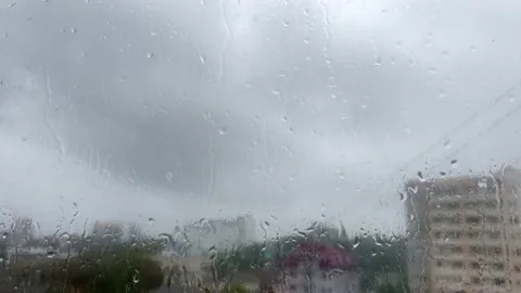 View of the rain through the glass from the middle of the house Stock Footage 211121187