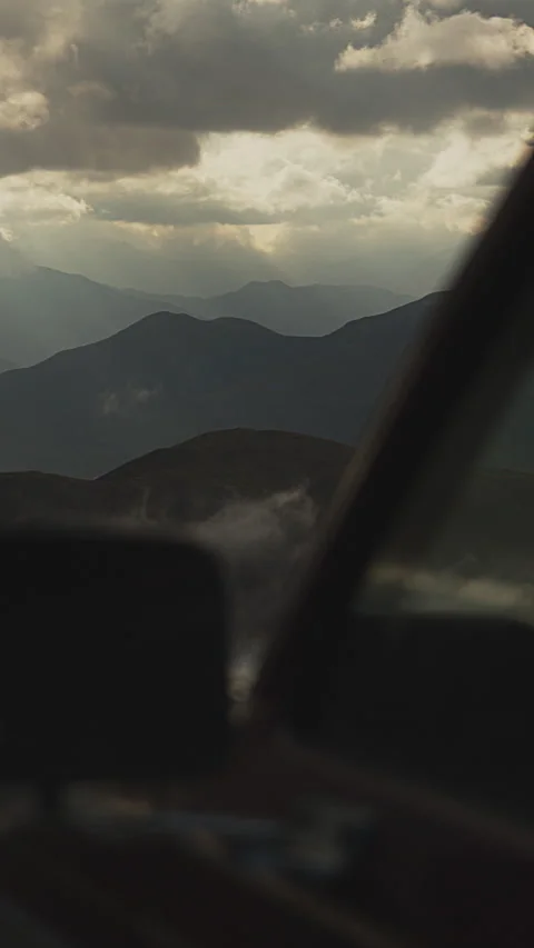 View of rainy sunset in the mountains through car window. Ethereal Mountain Stock Footage 273794002
