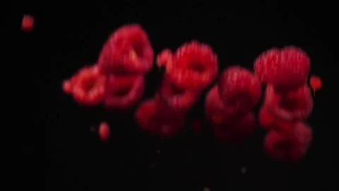 View of raspberries falling on black background Stock Footage 228642467