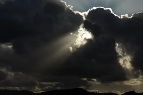View on the rays of the sun shine trough dark clouds Stock Photos