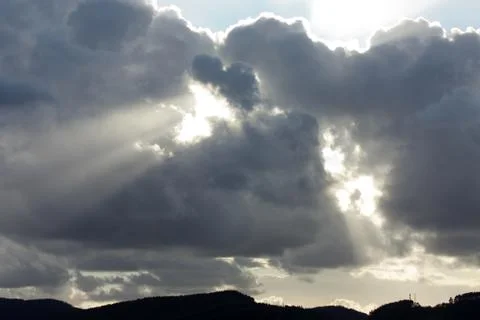 View on the rays of the sun shine trough dark clouds Stock Photos