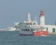 View of rear of boat moving past lighthouse SD Footage