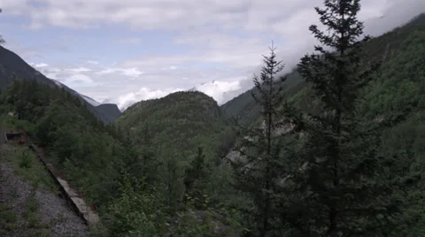 View from rear of train as it winds through mountains in Skagway, AK Stock Footage 36313158