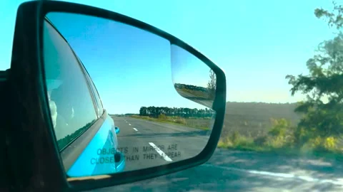 View in the rear view mirror of a car. Road trip. Summer car trip. Road Stock Footage 263729383