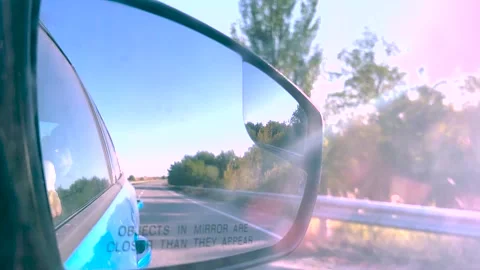 View in the rear view mirror of a car. Road trip. Summer car trip. Road Stock Footage 264541193