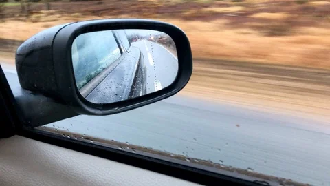 View of a rear view mirror while driving on the highway 4K Stock Footage 100685523