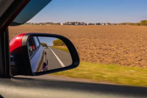 View in the rear view side mirror of a auto, driving a red car Stock Photos