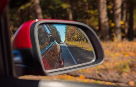View in the rear view side mirror of a auto, driving a red car Stock Photos