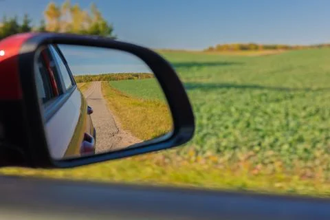 View in the rear view side mirror of a auto, driving a red car Stock Photos