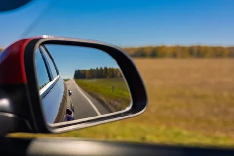 View in the rear view side mirror of a auto, driving a red car Stock Photos