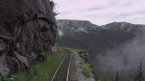 View from rear/side of train as it passes through mountains in Skagway, AK Stock Footage 36313218