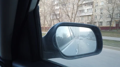 The view from the rearview mirror is of the car. Driving through the busy city s Stock Footage 120591407