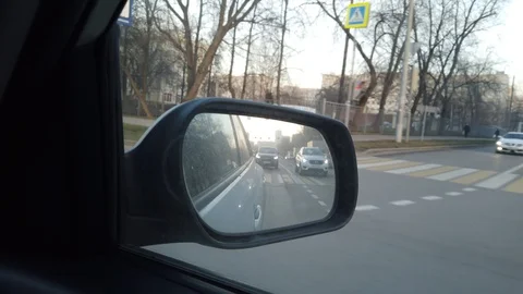 The view from the rearview mirror is of the car. Driving through the busy city Stock Footage 120592932
