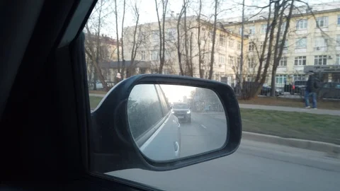 The view from the rearview mirror is of the car. Driving through the busy city Stock Footage 120593072