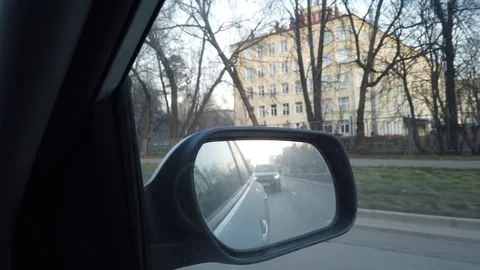 The view from the rearview mirror is of the car. Driving through the busy city Stock Footage 120593320
