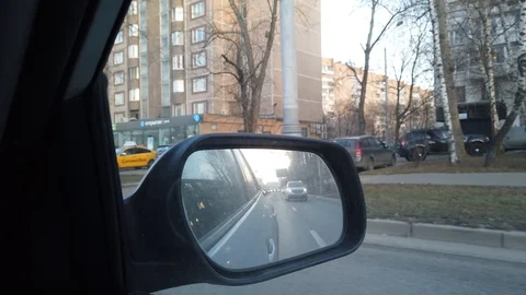 The view from the rearview mirror is of the car. Driving through the busy city Stock Footage 120594035