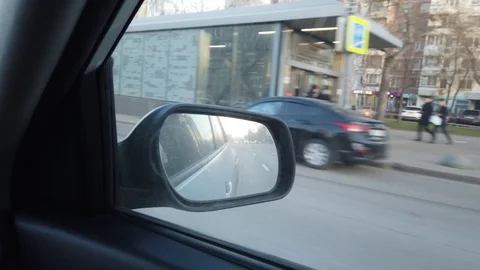The view from the rearview mirror is of the car. Driving through the busy city Stock Footage 120594611