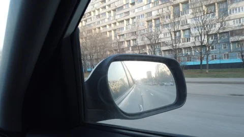 The view from the rearview mirror is of the car. Driving through the busy city Video stock 120594896
