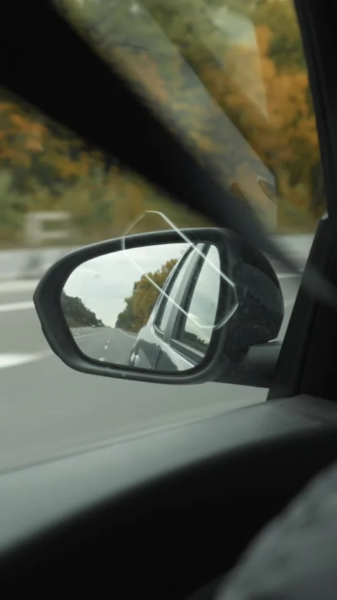 View of the rearview mirror through the car window during a trip Stock Footage 321353347