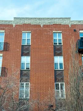 View of a red brick building with multiple windows and simple balconies aga.. Foto stock