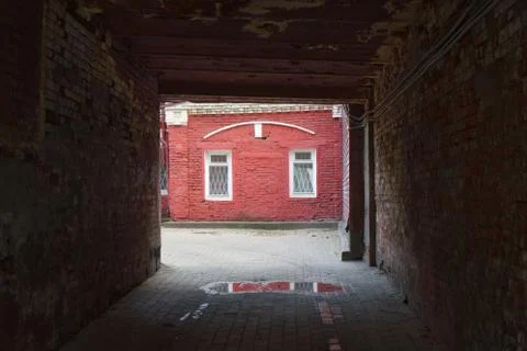 View of a red brick wall with windows through a brick arch Stock Photos