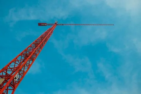 View of the red construction crane in the blue sky 库存照片