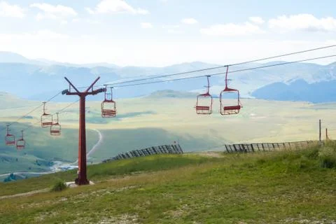 A view to red open cableway cabin over the top of the mountain Stock-Fotos