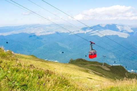 A view to red open cableway cabin over the top of the mountain and beautiful Foto stock