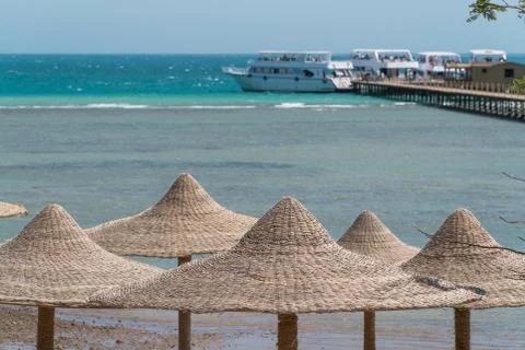 A view of the red sea in Egypt with wicker peaks from umbrellas in the foregr Foto stock