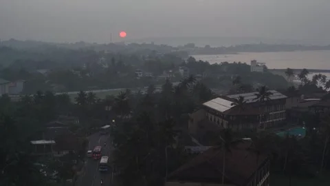 View of a red sunset over a misty coastal town, Sri Lanka. Vídeos de archivo 335601979
